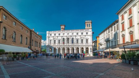 Foto de Plaza de la plaza principal Vecchia en una ciudad italiana Bergamo timelapse panorámica. Biblioteca, fuente y edificios históricos. Cielo azul en el día de verano - Imagen libre de derechos