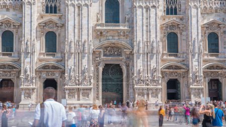 Photo for Entrance to Duomo cathedral. Front view with people walking on square. Gothic cathedral took nearly six centuries to complete. It is the fifth largest cathedral in the world and the largest in Italy - Royalty Free Image