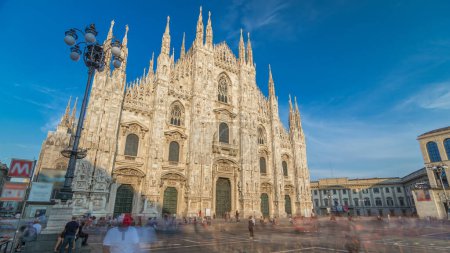 Téléchargez les photos : La cathédrale du Duomo au coucher du soleil avec ombre. Vue de face avec des gens marchant sur la place. La cathédrale gothique est la cinquième plus grande cathédrale au monde et la plus grande en Italie - en image libre de droit