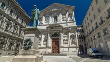 Photo for San Fedele Church with Alessandro Manzoni Statue timelapse hyperlapse, important Italian writer and poet of the nineteenth century, Milan city center, Italy. Blue sky at summer day - Royalty Free Image
