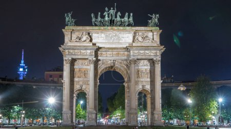 Foto de Arco della Pace en Piazza Sempione (Arco de la Paz en la Plaza Simplon) timelapse iluminado por la noche. Es un arco de triunfo neoclásico, construido entre 1807 y 1838. Tráfico en segundo plano - Imagen libre de derechos