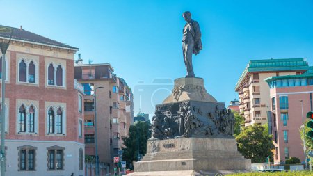 Foto de Estatua de Giuseppe Verdi, en el frente de Casa Verdi timelapse Milán, Italia. Tráfico en la carretera. Cielo azul en el día de verano - Imagen libre de derechos
