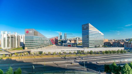 Photo for Modern buildings in the new area of Portello panoramic timelapse, Milan, Italy. Top view with traffic on the road. Blue cloudy sky at summer day. - Royalty Free Image