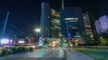 Photo for Milan skyline with modern skyscrapers in Porta Nuova business district night timelapse in Milan, Italy. Traffic on the road. Light in windows. View from road - Royalty Free Image