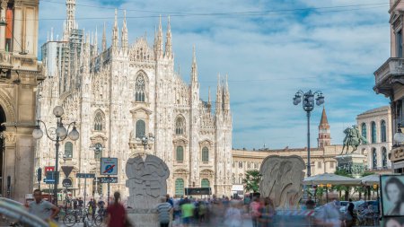 Téléchargez les photos : Le timelapse de la cathédrale du Duomo. Vue de face depuis la Piazza dei Mercanti avec des personnes marchant sur la place. Ciel bleu le jour d'été. La cathédrale gothique a pris près de six siècles à compléter. - en image libre de droit