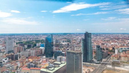 Foto de Panorama de Milán vista aérea de las modernas torres y rascacielos y la estación de tren de Garibaldi en el distrito de negocios vista desde la azotea. Casas con techos rojos. Cielo azul nublado en el día de verano - Imagen libre de derechos