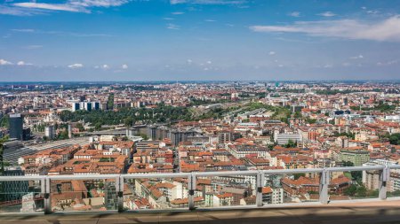 Vista aérea de Milán de los edificios residenciales y la estación de tren de Garibaldi en el distrito de negocios timelapse vista desde la azotea. Casas con techos rojos. Cielo azul nublado en el día de verano