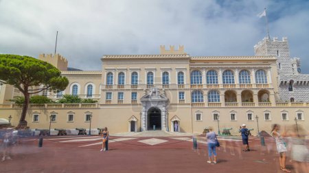 Téléchargez les photos : Façade du Palais Princier de Monaco hyperlapsus intemporel et place devant lui. C'est la résidence officielle du Prince de Monaco. Ciel nuageux le jour d'été. Des gens qui marchent - en image libre de droit