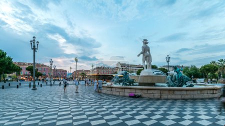 Photo for The Fountain du Soleil on Place Massena square Nice day to night transition timelapse, French Riviera, Cote d'Azur, France. Street lights and illuminated buildings - Royalty Free Image