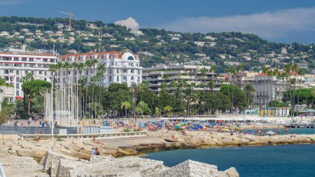 Photo for Colorful old town buildings and beach in Cannes timelapse on French Riviera in a beautiful summer day, France. Azur sea with waterfront - Royalty Free Image