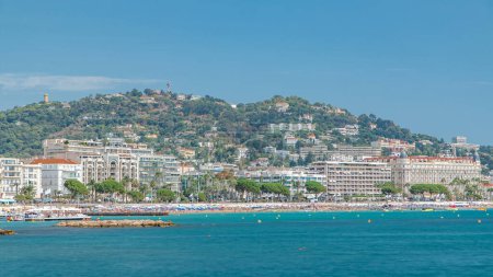Photo for Colorful old town buildings and beach in Cannes timelapse on french Riviera in a beautiful summer day, France. Azur sea and green hills on a background - Royalty Free Image