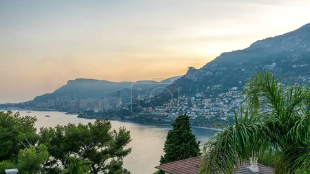 Cityscape of Monte Carlo day to night transition timelapse, Monaco after summer sunset. Evening mist. Yachts on harbor. Top panoramic view from Cap Martin