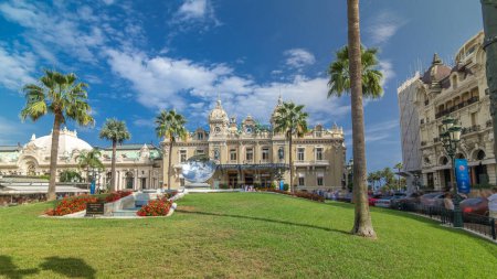 Téléchargez les photos : Vue de face du Grand Casino à Monte Carlo timelapse hyperlapse, Monaco. bâtiment historique et place avec fontaine et herbe verte. Les paumes sur le côté. Ciel bleu nuageux le jour d'été - en image libre de droit
