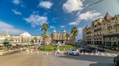 Foto de Vista frontal del Grand Casino en Monte Carlo timelapse, Mónaco. edificio histórico y plaza con fuente y hierba verde. Las palmas al costado. Estacionamiento. Cielo azul nublado en el día de verano - Imagen libre de derechos