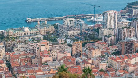 Téléchargez les photos : Paysage urbain de Monte Carlo, Monaco passage du jour à la nuit timelapse avec toits de bâtiments et place du casino après le coucher du soleil. Vue aérienne du dessus depuis les collines. - en image libre de droit