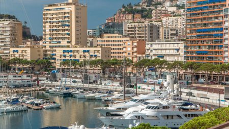 Téléchargez les photos : Monte Carlo ville panorama aérien timelapse. Vue d'en haut de yachts de luxe, bateaux et bâtiments résidentiels dans le port de Monaco, Côte d'Azur. Port Hercule par le haut. - en image libre de droit
