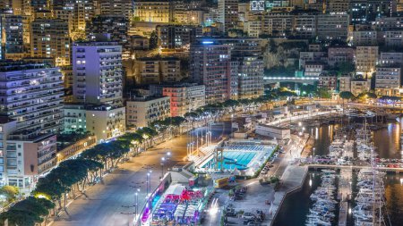 Foto de Piscina junto al mar en Mónaco noche timelapse, edificios en el fondo. Vista aérea superior. Tráfico en la carretera de terraplén - Imagen libre de derechos