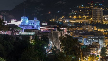 Téléchargez les photos : Palais Princier de Monaco illuminé par un timelapse aérien de nuit avec pont d'observation. Résidence officielle du Prince de Monaco. Skyline de ville - en image libre de droit