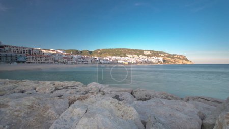 Sunset from pier at small town of Sesimbra Portugal, shadow move on hill, panoramic timelapse