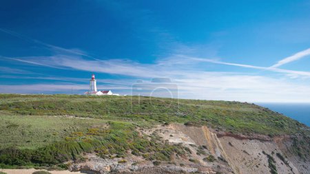 Lighthouse of Cape Espichel with moving clouds near Atlantic ocean, view from the temple, Portugal timelapse