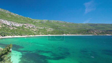 Téléchargez les photos : Baie de plage à Portinho da Arrabida avec eau turquoise et collines verdoyantes, Portugal timelapse aérien - en image libre de droit