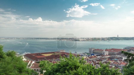 Photo for Aerial panoramic view of the historical Lisbon Baixa downtown and Tagus River with boats, from the Sao Jorge St. George Castle in Lisbon, Portugal timelapse. Clouds and green trees - Royalty Free Image