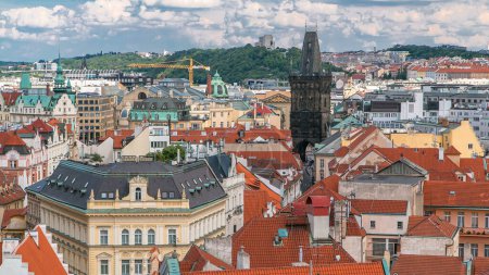 Luftaufnahme der traditionellen roten Dächer der Stadt Prag, Tschechische Republik mit dem Pulverturm und Vitkov-Hügel in der Ferne Zeitraffer. Blick von oben auf den alten Rathaussturm