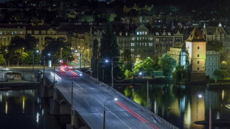 Photo for Jirasek Bridge on the Vltava river with traffic night aerial timelapse in Prague, Czech Republic. View from top of dancing house - Royalty Free Image