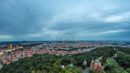 Maravillosa vista panorámica del timelapse de transición del día a la noche a la ciudad de Praga desde la torre de observación de Petrin en República Checa. Coudy cielo en el día de verano.