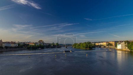 Vltava river timelapse hyperlapse in district Strelecky ostrov with the bridge of the Legions (Most legii) and National Theater building early morning, Prague, Czech Republic. From Charles bridge