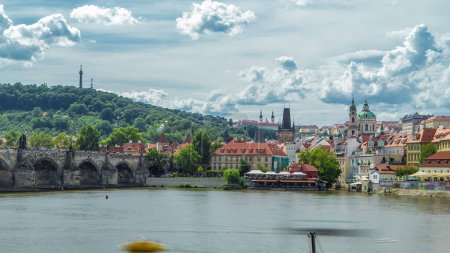 Téléchargez les photos : Vltava remblai de la rivière timelapse par une journée d'été ensoleillée. Prague, République tchèque. Pont Charles, tours et colline Petrin - en image libre de droit