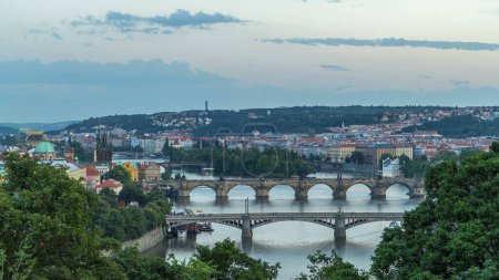 Téléchargez les photos : Vue panoramique sur les ponts sur la rivière Vltava timelapse de transition de jour à la nuit et du centre historique de Prague : bâtiments et monuments de la vieille ville avec des toits rouges et des murs multicolores. - en image libre de droit