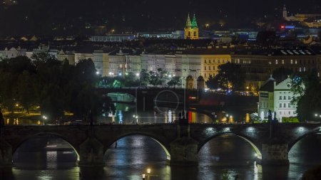 Téléchargez les photos : Vue panoramique sur les ponts sur la rivière Vltava timelapse nocturne et du centre historique de Prague : bâtiments et monuments de la vieille ville avec pont Charles et murs multicolores. - en image libre de droit
