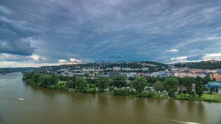 Foto de Vista aérea del timelapse de Praga desde la plataforma de observación de Visegrad. Praga. República Checa. Río Moldava y árboles verdes. Clima tormentoso con nubes oscuras - Imagen libre de derechos