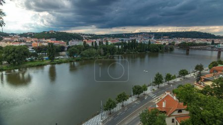 Aerial view of Prague timelapse from the observation deck of Visegrad. Prague. Czech Republic. Vltava river and bridges with traffic on a road. Stormy weather with dark clouds