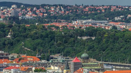 Panoramic view of Prague timelapse from the top of the Vitkov Memorial, Czech Republic. Old Town with red roofs and metronome. Cloudy sky at summer day