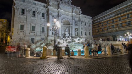 Téléchargez les photos : La célèbre fontaine de Trevi la nuit timelapse hyperlapsus. Cet endroit est l'un des plus visités de Rome. La foule reste dans le coin. - en image libre de droit