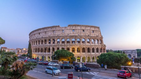 Téléchargez les photos : Colosseum day to night after sunset, Rome. Evening illumination. Traffic on the road. Rome best known architecture and landmark. Rome Colosseum is one of the main attractions of Rome and Italy - en image libre de droit