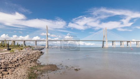 Téléchargez les photos : Panorama montrant le front de mer et le pont Vasco da Gama timelapse. Pont à haubans le plus long flanqué de viaducs et offrant une vue sur le Tage dans le Parc des Nations de Lisbonne, Portugal - en image libre de droit