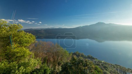 Sunrise Serenity : Albano Lake Coast Panoramic Timelapse, Rome Province, Latium, Italie centrale. La lumière du matin réveille le paysage, peint la scène avec la beauté tranquille des arbres verts