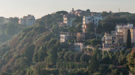 Zeitraffer der Seeküste von Albano, Provinz Rom, Latium, Mittelitalien. Ein ruhiger Morgen erhellt Häuser und Bäume mit der Wärme des ersten Lichts