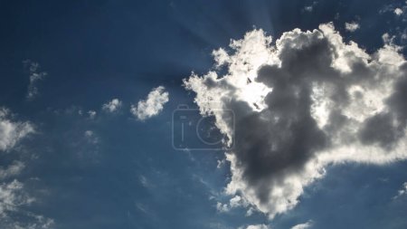 Photo for Beautiful cloudscape timelapse with large, building clouds and sunrise breaking through cloud mass on blue sky. - Royalty Free Image