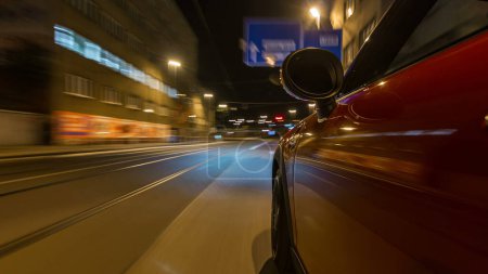 Foto de El coche se mueve a velocidad rápida en las calles nocturnas timelapse hyperlapse drivelapse. Carretera borrosa con luces reflejadas desde el coche a alta velocidad. Praga, Checa - Imagen libre de derechos