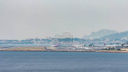 Téléchargez les photos : Vue aérienne de l'aéroport de Nice dans le sud de la France timelapse. Avions atterrissage et décollage - en image libre de droit