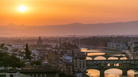 Skyline view of Arno River aerial timelapse. Ponte Vecchio from Piazzale Michelangelo at Sunset, Florence, Italy. Orange sky. Evening mist