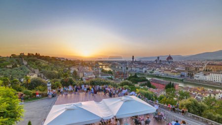 Photo for Skyline panoramic view of Arno River aerial timelapse. Ponte Vecchio from Piazzale Michelangelo at Sunset, Florence, Italy. Crowd on viewpoint. Colorful sky. Evening mist - Royalty Free Image