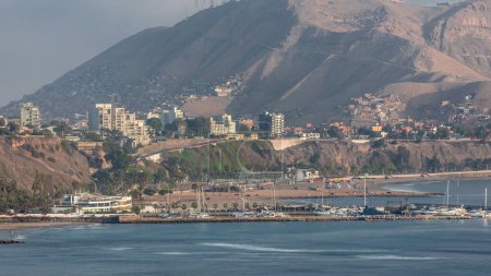 Aerial view of Lima's Coastline with Morro Solar hill in background timelapse, Lima, Peru. Harbor with yachts and beach with ocean. View from cliff near Circuito de Playas road