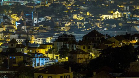 Foto de Vista aérea de Funchal por la noche timelapse, Isla Madeira, Portugal. Edificios iluminados en una plaza central y calles de la ciudad - Imagen libre de derechos