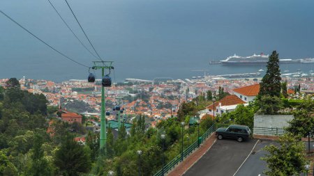 Foto de Vista aérea con teleférico en Madeira timelapse. Vista general del océano con barco en el puerto sobre los tejados. El paisaje moderno. Funchal, Portugal. - Imagen libre de derechos
