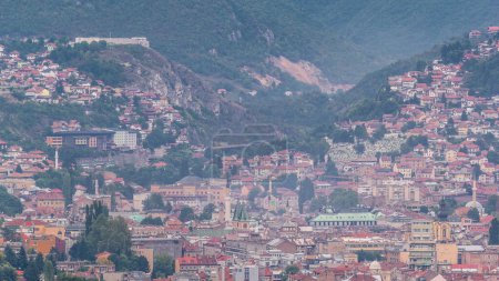 Téléchargez les photos : Vue aérienne de la partie historique de Sarajevo timelapse ville. Skyline avec gratte-ciel et montagnes du plus haut point de vue de la tour avant le coucher du soleil. Bosnie-Herzégovine, Europe du Sud-Est
. - en image libre de droit